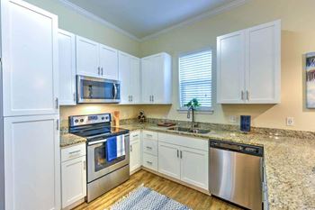 a kitchen with a stove top oven next to a window  at Palm Bay Club, Florida
