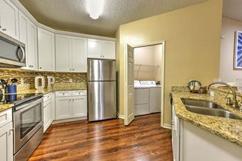 a kitchen with white cabinets and a stainless steel refrigerator  at Ocean Park, Jacksonville Beach, Florida