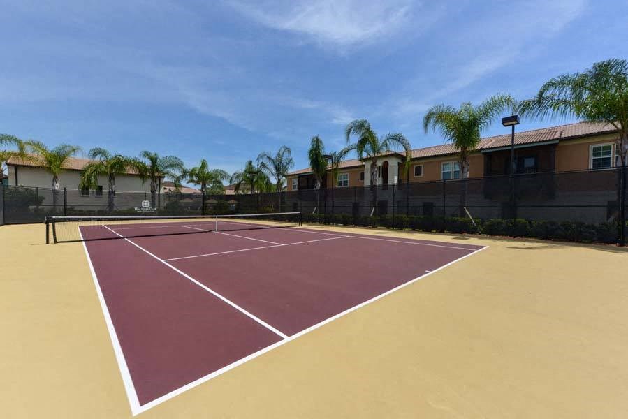 a tennis court with palm trees in the background  at Hacienda Club, Jacksonville, 32256