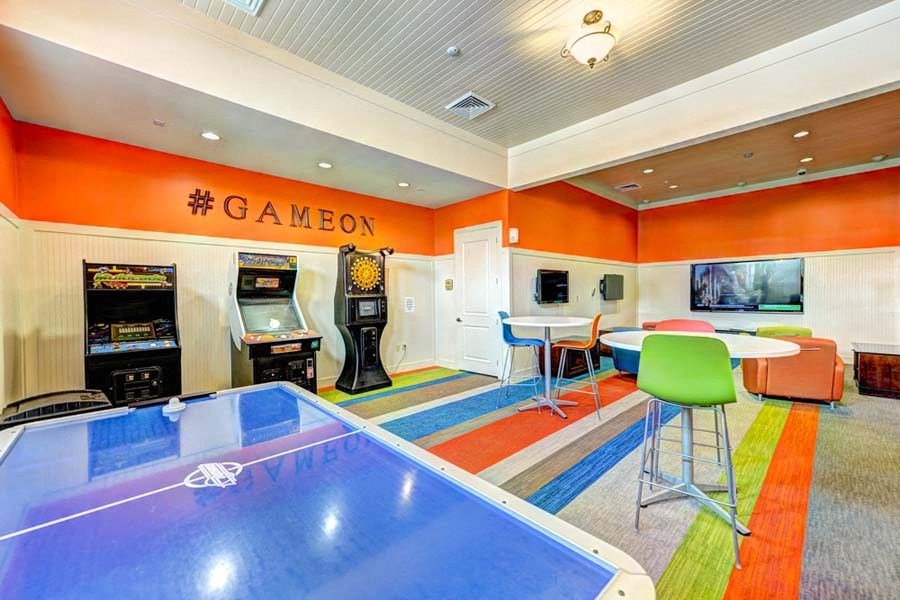 a game room with a ping pong table and arcade games  at Hacienda Club, Jacksonville, 32256
