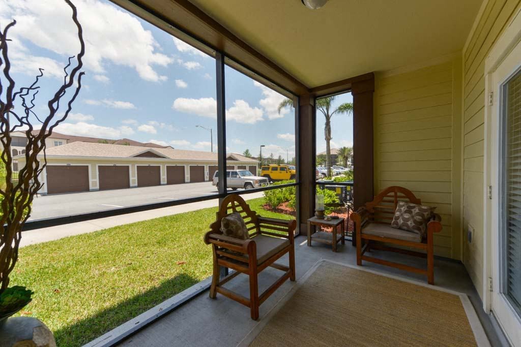 a porch with two chairs and a grassy area  at Cabana Club - Galleria Club, Florida