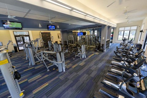 a large fitness room with cardio equipment and flat screen tvs  at Cabana Club - Galleria Club, Jacksonville, Florida