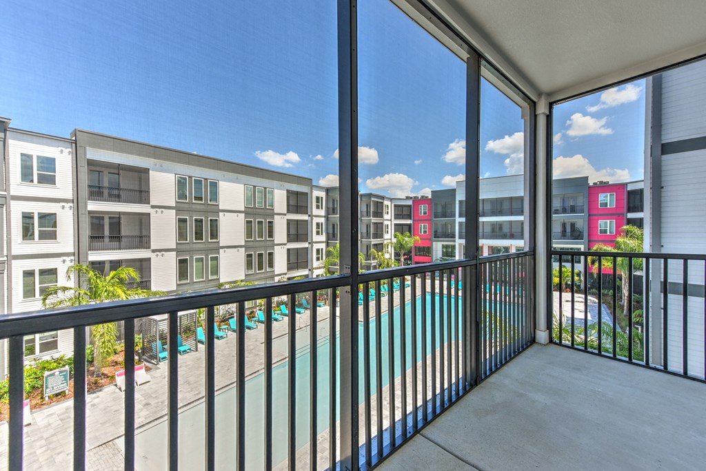 A balcony with a pool and a view of apartment buildings at Pinnacle Apartments, Jacksonville, FL