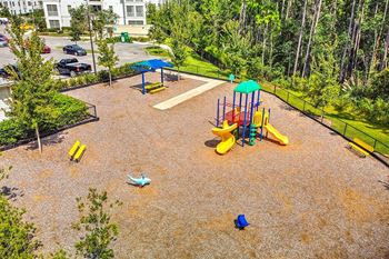 a playground in a park with a parking lot in the background  at Palm Bay Club, Jacksonville, 32258