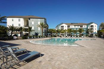 a resort style pool with chaise lounge chairs and buildings in the background  at Fountainhead, Florida