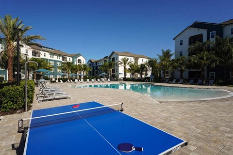 a blue ping pong table sitting next to a swimming pool  at Fountainhead, Jacksonville, FL, 32258