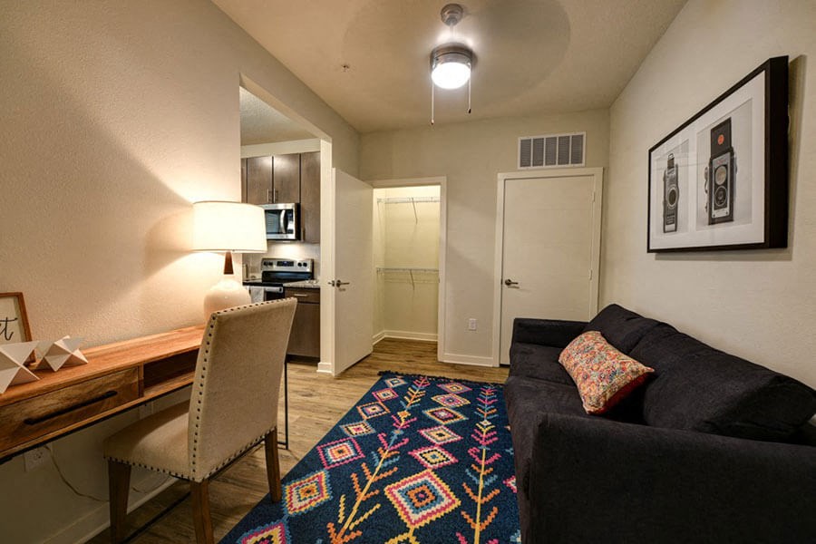 a living room with a couch and chair in front of a desk with a lamp and a  at Fusion, Jacksonville, Florida