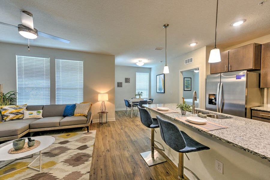 a living room and kitchen area with a couch and a table  at Fusion, Jacksonville, FL