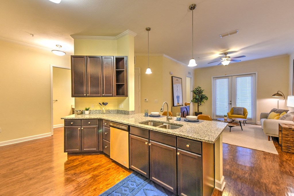 A kitchen with a granite countertop and stainless steel appliances at Alaqua, Florida, 32258