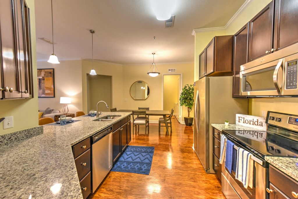 A kitchen with granite countertops and stainless steel appliances at Alaqua, Florida, 32258