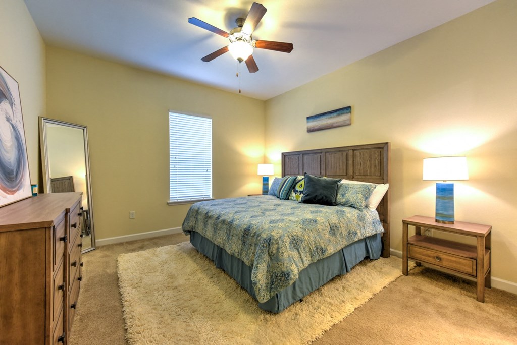 A bedroom with a bed, dresser, and ceiling fan at Alaqua, Florida, 32258