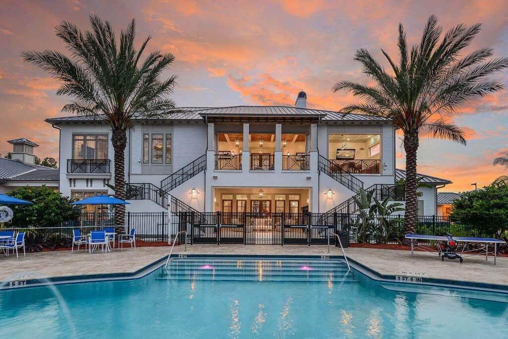 a large white house with a pool in front of it  at Palm Bay Club, Florida, 32258