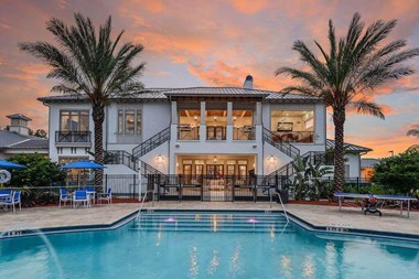 a large white house with a pool in front of it - Photo Gallery 2