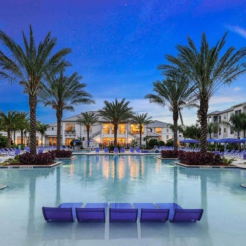 a large pool with a bunch of palm trees in front of a building  at Palm Bay Club, Jacksonville
