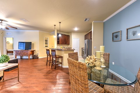A living room with a glass table and wicker chairs at Cabana Club - Galleria Club Apartments, Florida