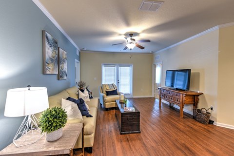 A living room with a couch, a coffee table, and a ceiling fan at Cabana Club - Galleria Club Apartments, Jacksonville, FL, 32256