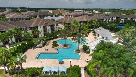 A large swimming pool surrounded by palm trees and a resort at Cabana Club - Galleria Club Apartments, Jacksonville, Florida