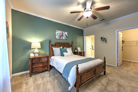 A bedroom with a bed, dresser, and ceiling fan at Cabana Club - Galleria Club Apartments, Jacksonville, Florida