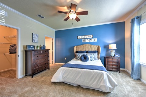 A bedroom with a bed, dresser, and ceiling fan at Cabana Club - Galleria Club Apartments, Jacksonville