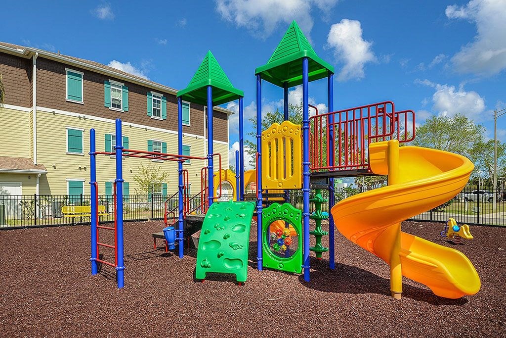 a playground with a slide and other toys in front of a building  at Cabana Club - Galleria Club, Jacksonville, Florida