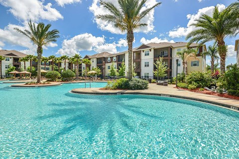 a swimming pool with palm trees in front of an apartment complex  at Cabana Club - Galleria Club, Florida