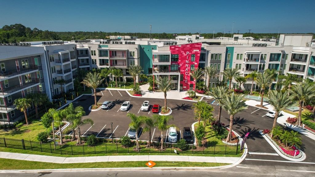 an aerial view of an apartment complex with parking lot and palm trees at Pinnacle Apartments, Florida, 32256