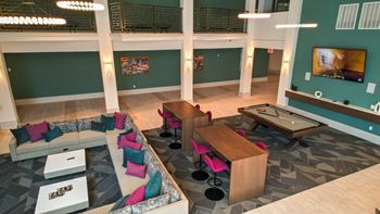 a large living room with a billiards table and couches at Pinnacle Apartments, Jacksonville, FL