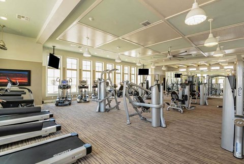 a spacious fitness center with cardio equipment and a flat screen tv  at Palm Bay Club, Jacksonville, Florida