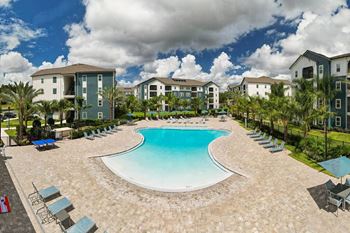 an aerial view of a resort style pool with lounge chairs and umbrellas at Fountainhead, Jacksonville, FL