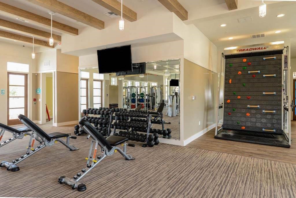 a spacious fitness center with cardio equipment and a large screen tv  at Palm Bay Club, Florida
