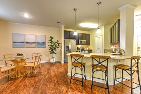 A kitchen with a bar area and a dining table at Cabana Club - Galleria Club Apartments, Jacksonville
