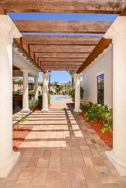 a covered walkway with a pool in the background  at Hacienda Club, Jacksonville, 32256