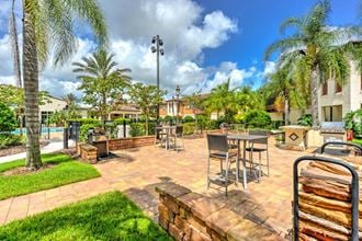 a patio with tables and chairs and a pool in the background  at Hacienda Club, Jacksonville - Photo Gallery 3