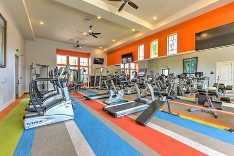 a gym with treadmills and other exercise equipment and windows at Hacienda Club, Jacksonville, Florida