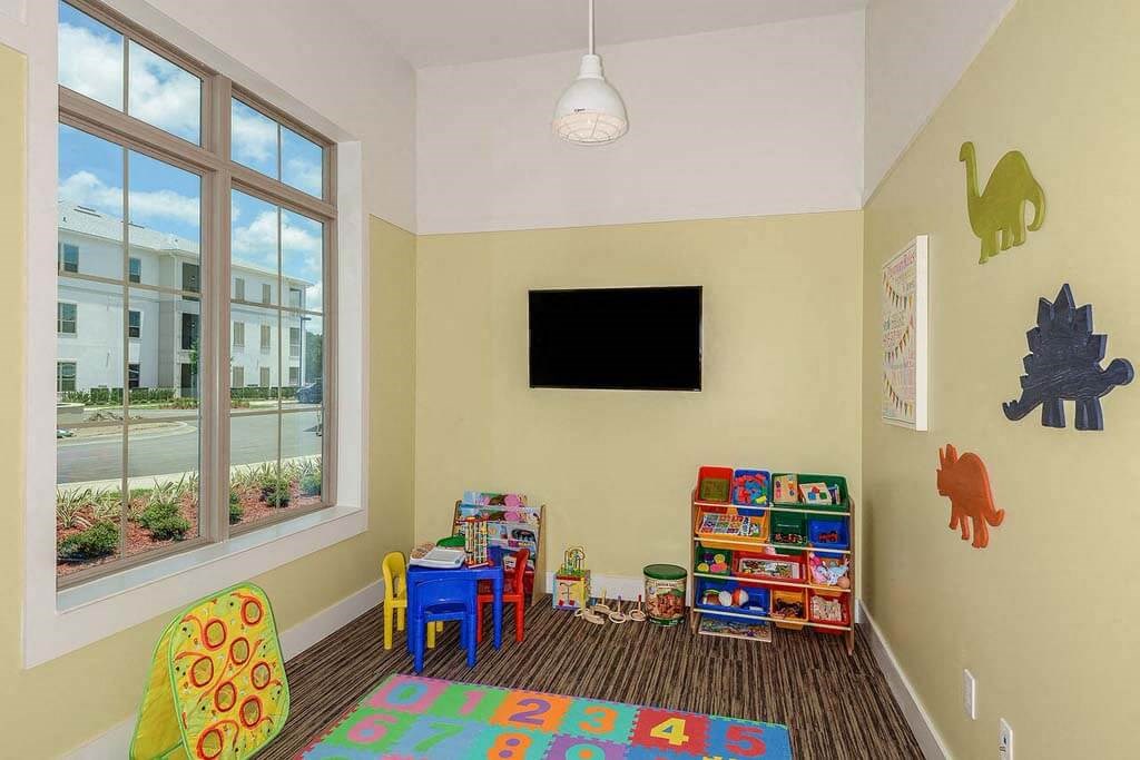 a room with a television and children's toys  at Palm Bay Club, Jacksonville, FL