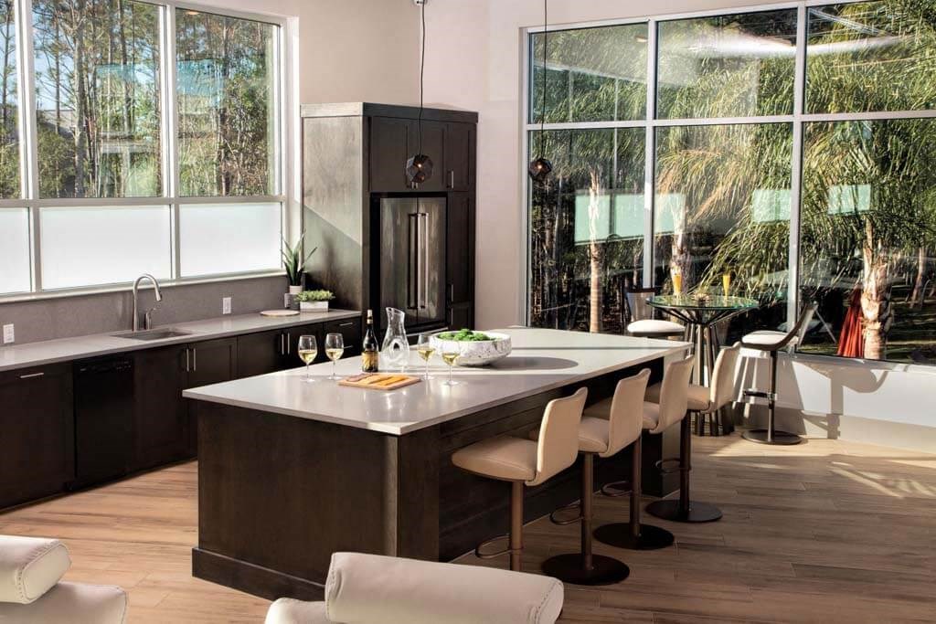 a kitchen with a large center island next to a window a kitchen with a large center island next to a window at Luxor Club, Jacksonville, Florida
