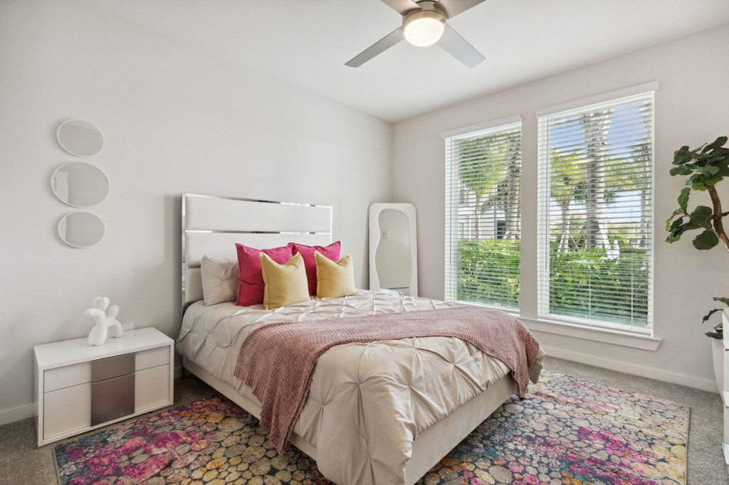 A bedroom with a large bed and a ceiling fan. at Pinnacle Apartments, Jacksonville, 32256