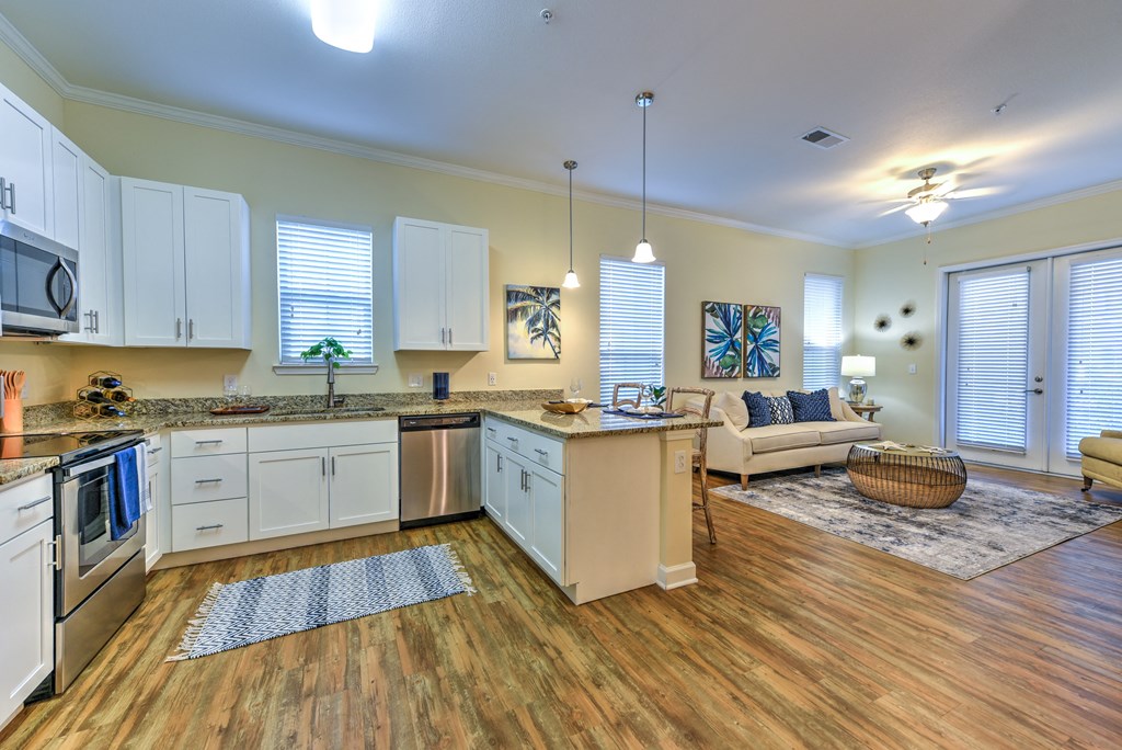 a kitchen and living room with hardwood floors and white cabinets at Palm Bay Club, Jacksonville, 32258