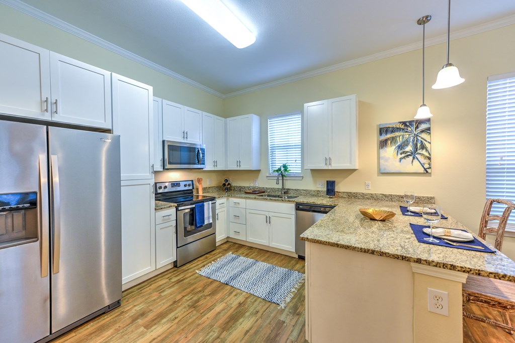 a kitchen with white cabinets and stainless steel appliances at Palm Bay Club, Jacksonville, FL