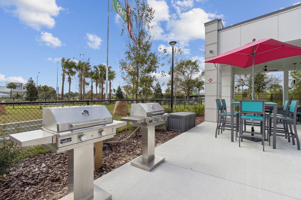 A barbecue grill is in front of a building with a red awningat Pinnacle Apartments, Jacksonville, FL