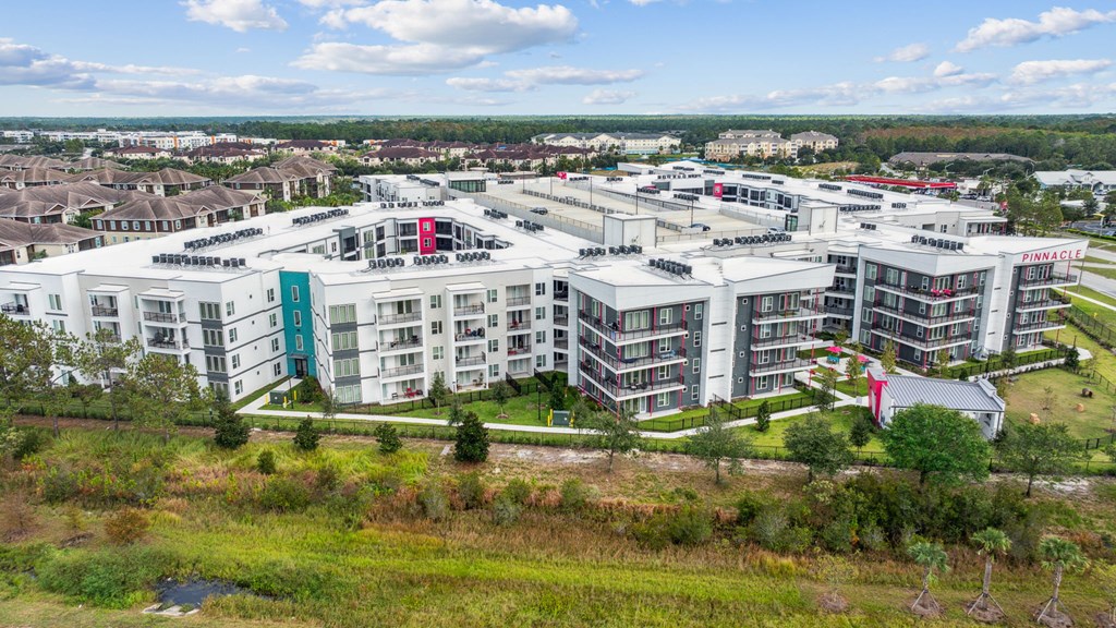 A large white building complex with a red roofat Pinnacle Apartments, Jacksonville, FL