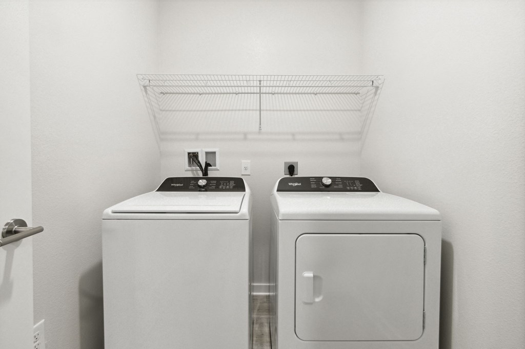 A white bathroom with a washer and dryerat Pinnacle Apartments, Jacksonville, FL