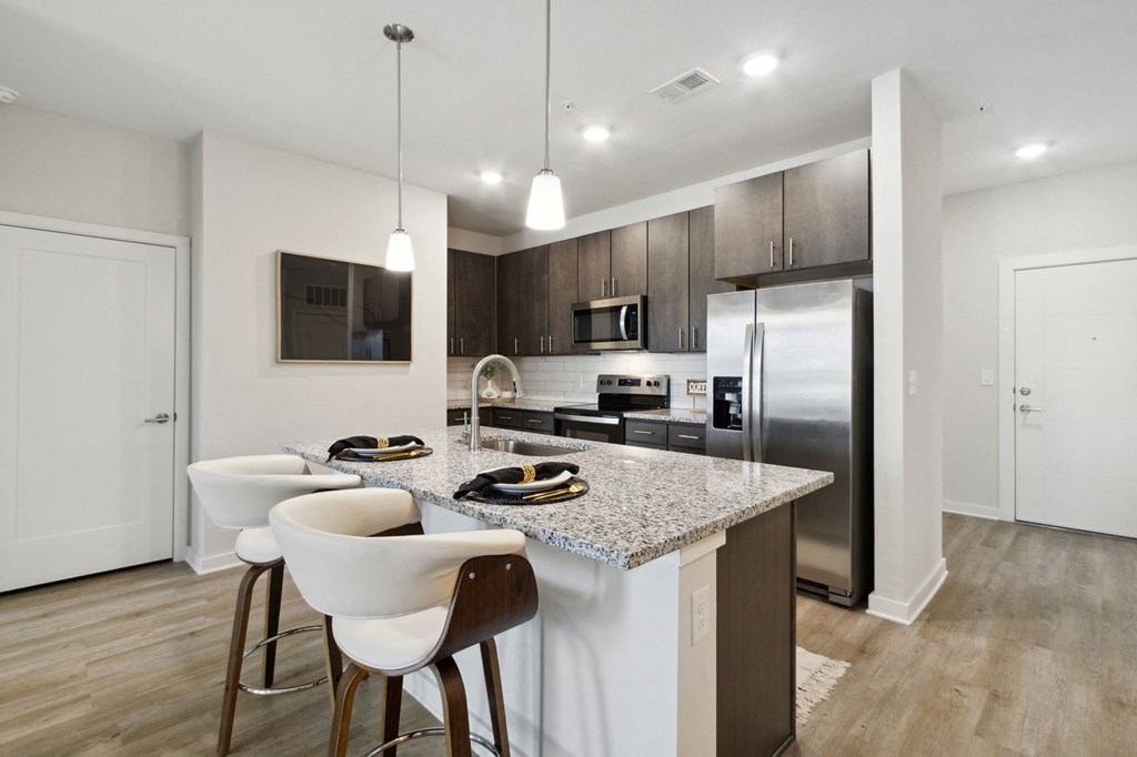 A modern kitchen with a granite countertop and stainless steel appliancesat Pinnacle Apartments, Jacksonville, FL