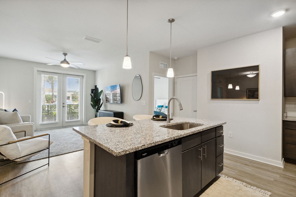 A modern kitchen with a granite countertop and stainless steel appliancesat Pinnacle Apartments, Jacksonville, FL