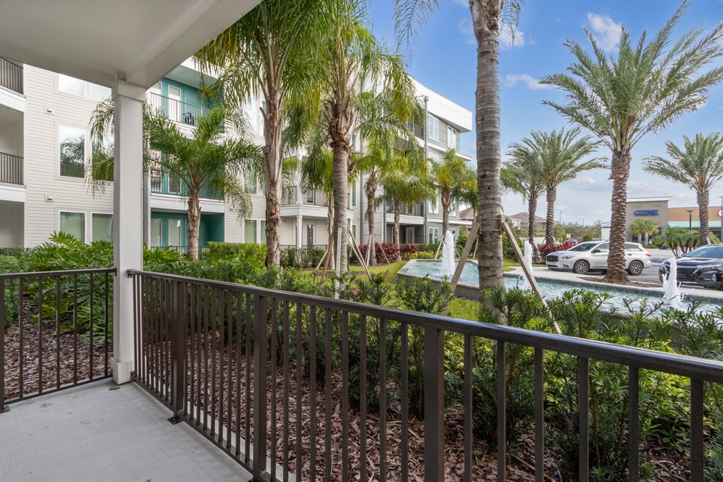 A balcony with a railing and a view of a building and treesat Pinnacle Apartments, Jacksonville, FL