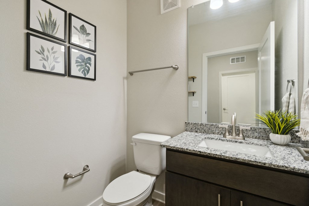 A bathroom with a toilet, sink, and mirrorat Pinnacle Apartments, Jacksonville, FL
