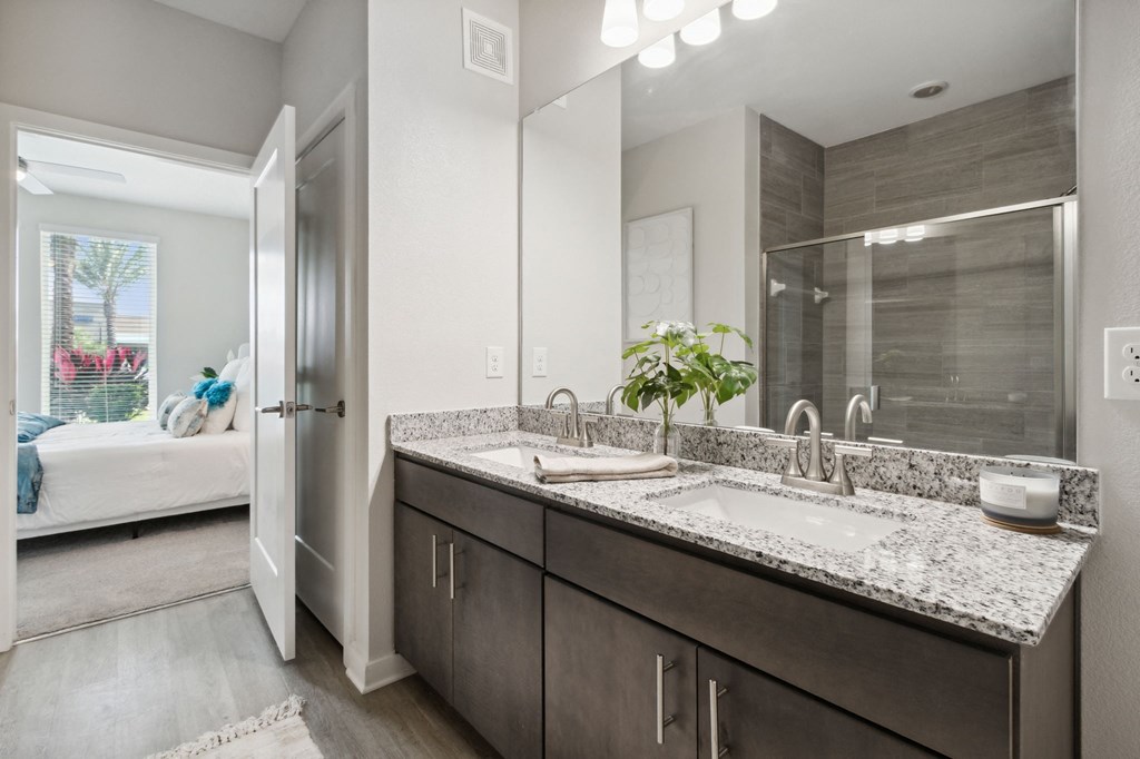 A bathroom with a double sink vanity and a mirror above itat Pinnacle Apartments, Jacksonville, FL