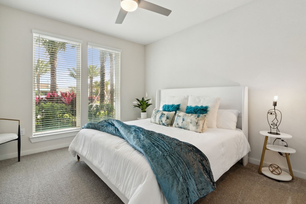 A bedroom with a bed, a fan, and a window with blindsat Pinnacle Apartments, Jacksonville, FL