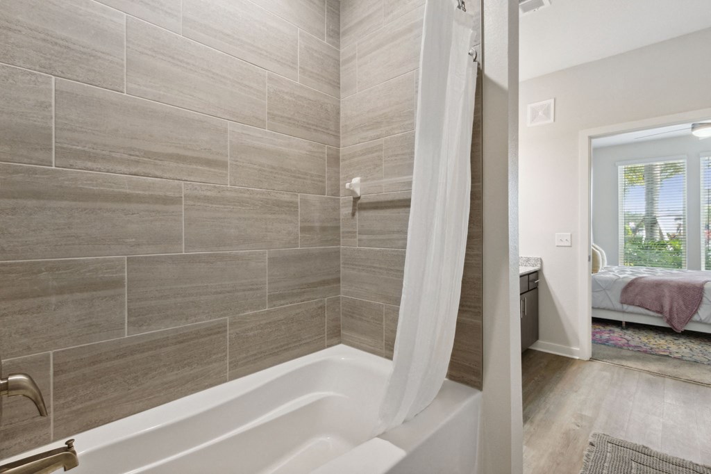 A bathroom with a tub and a windowat Pinnacle Apartments, Jacksonville, FL