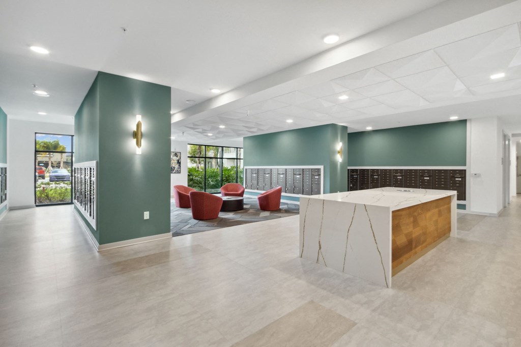 A reception area with a white reception desk and a green wallat Pinnacle Apartments, Jacksonville, FL